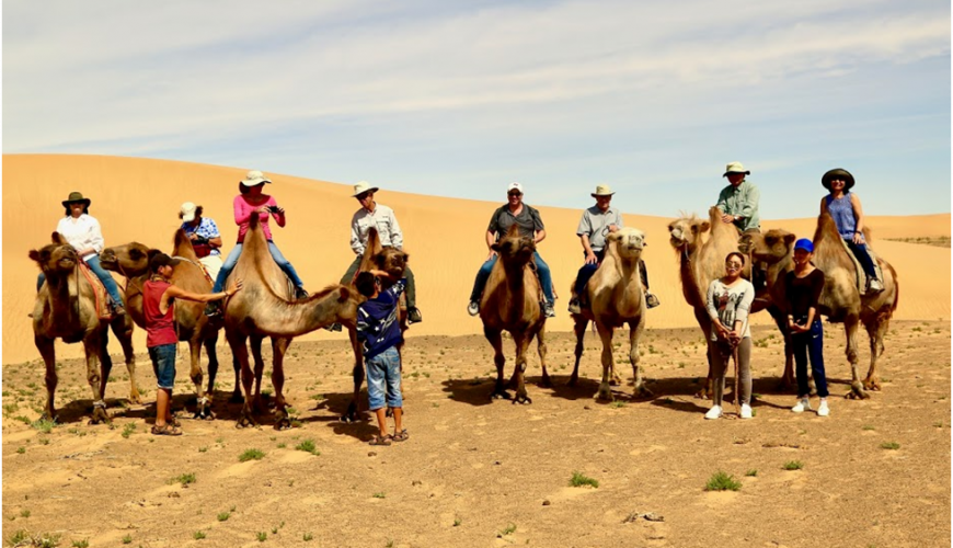 Riding a Bactrian camel in Mongolian Gobi desert