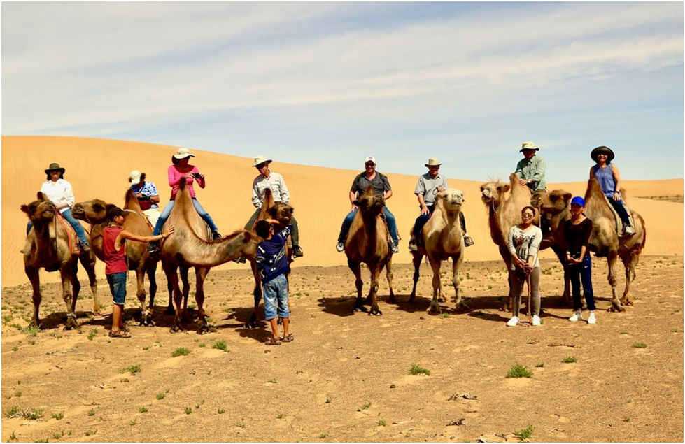 Riding a Bactrian camel in Mongolian Gobi desert